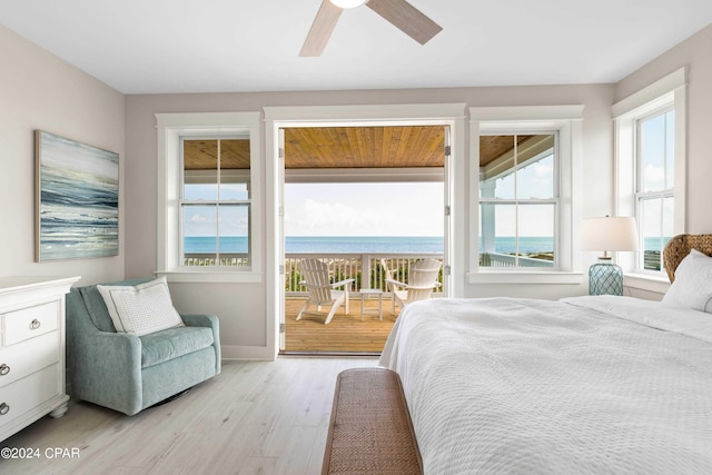 bedroom featuring access to exterior, ceiling fan, light hardwood / wood-style flooring, and a water view