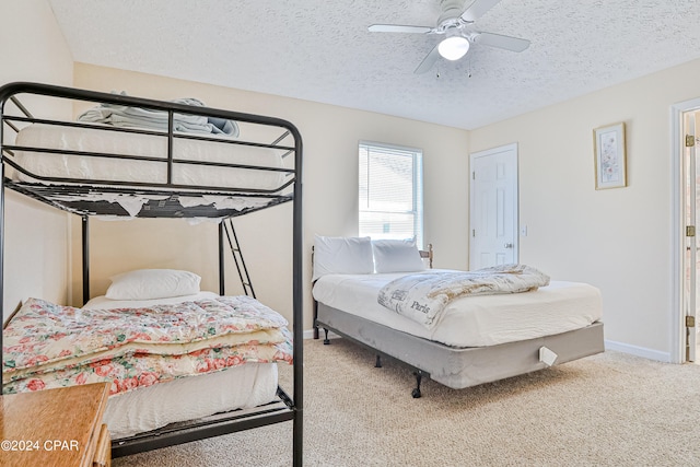 carpeted bedroom featuring ceiling fan and a textured ceiling