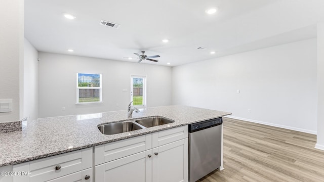 kitchen featuring sink, dishwasher, light stone counters, and white cabinets