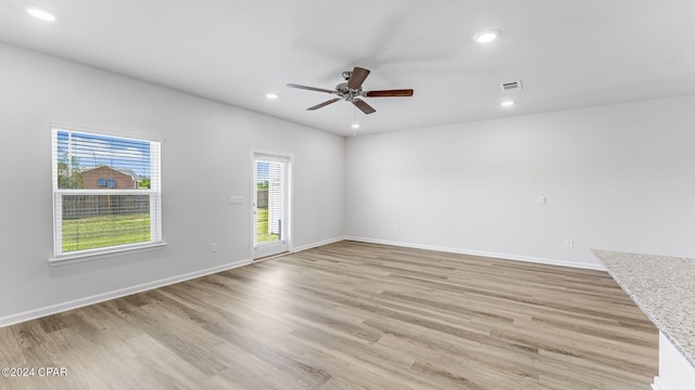 spare room with ceiling fan and light wood-type flooring