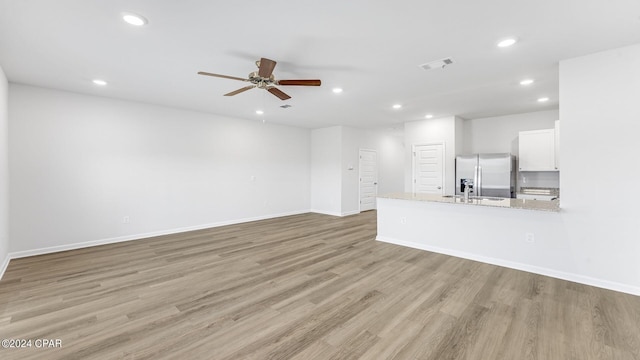 unfurnished living room with ceiling fan and light hardwood / wood-style floors