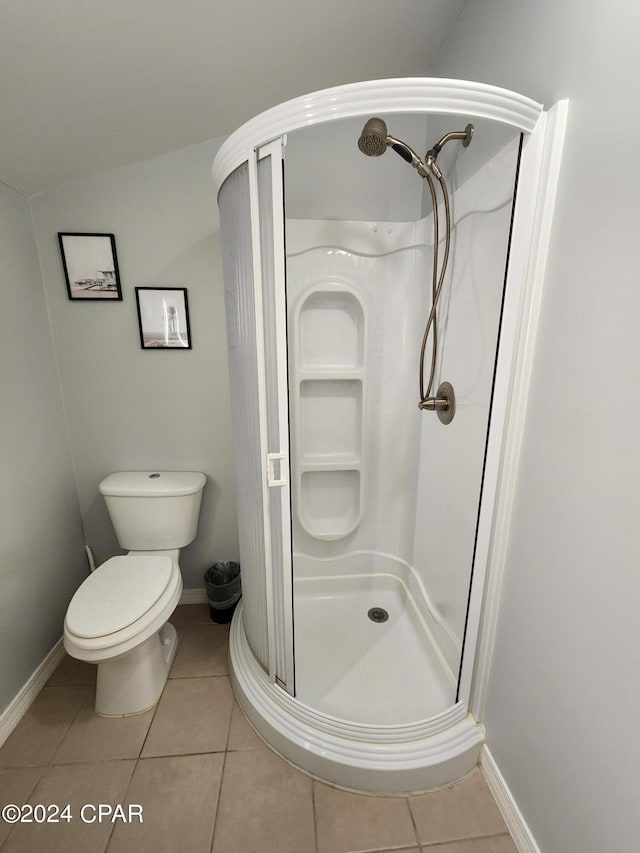 bathroom with tile patterned floors, toilet, vaulted ceiling, and walk in shower