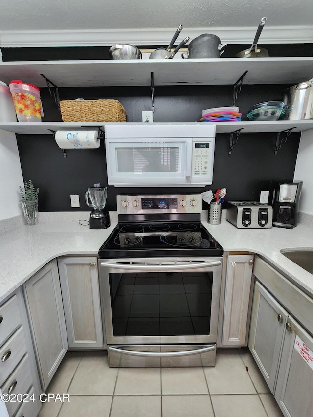 kitchen featuring gray cabinets, stainless steel range with electric stovetop, and light tile patterned flooring