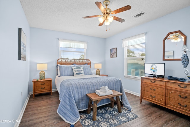 bedroom with multiple windows, ceiling fan, and dark hardwood / wood-style flooring