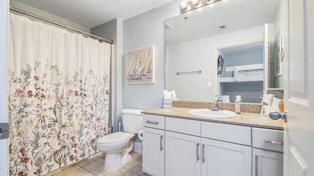 bathroom with tile patterned flooring, vanity, and toilet