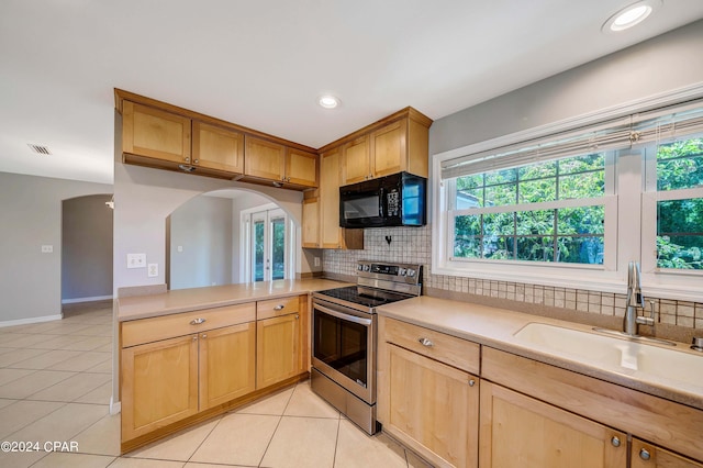 kitchen featuring backsplash, sink, electric range, light tile patterned flooring, and kitchen peninsula