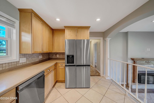 kitchen with light tile patterned floors, light brown cabinetry, appliances with stainless steel finishes, and tasteful backsplash