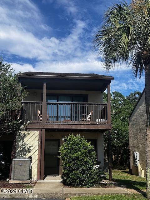 view of front of property featuring a balcony and cooling unit