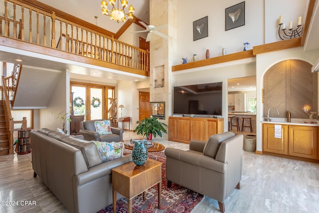 living room with ceiling fan with notable chandelier and a towering ceiling