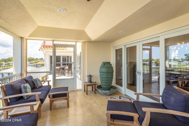 sunroom featuring french doors and a raised ceiling