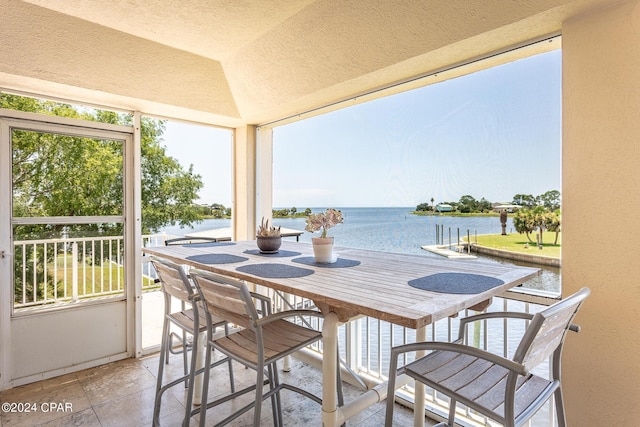 sunroom with a water view and lofted ceiling