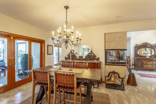 dining area featuring french doors, light hardwood / wood-style flooring, and a notable chandelier