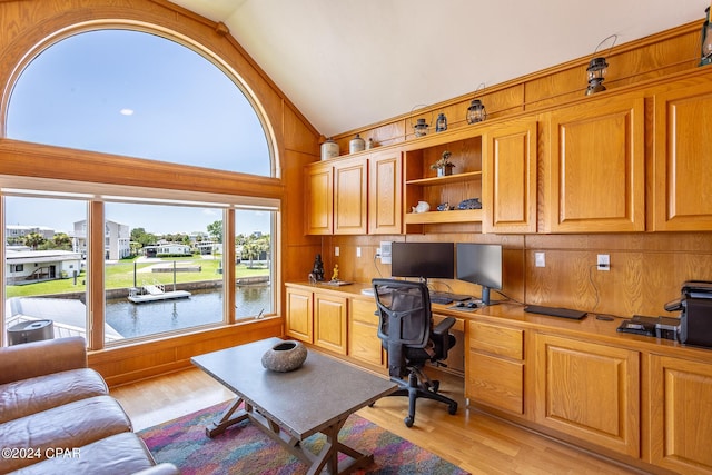 home office featuring built in desk, light hardwood / wood-style flooring, and vaulted ceiling