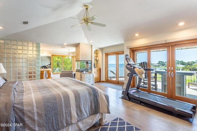 bedroom with access to exterior, french doors, light wood-type flooring, vaulted ceiling, and ceiling fan