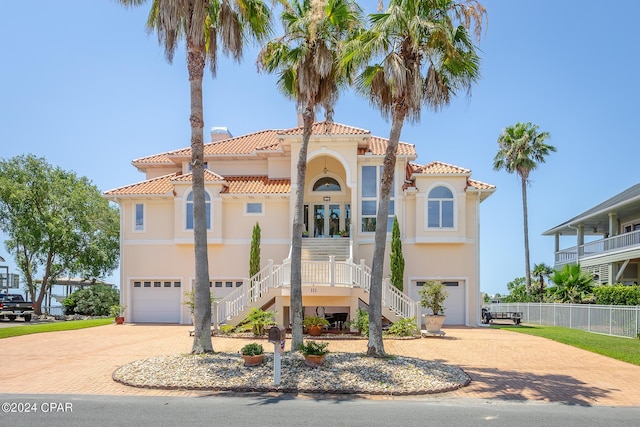 mediterranean / spanish-style home featuring covered porch and a garage