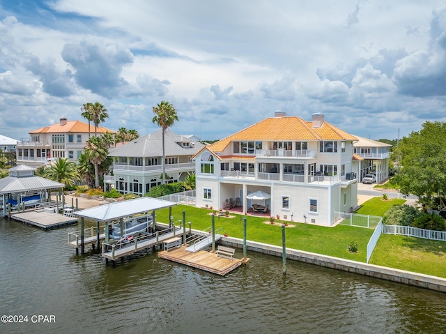 view of dock featuring a lawn, a water view, and a balcony