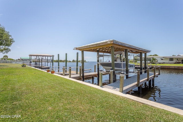dock area featuring boat lift, a yard, and a water view