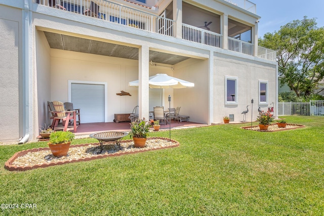 rear view of house with a lawn and a patio