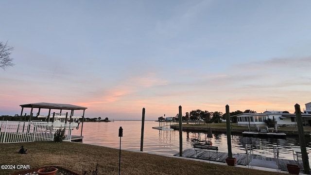 view of dock featuring a water view and a lawn