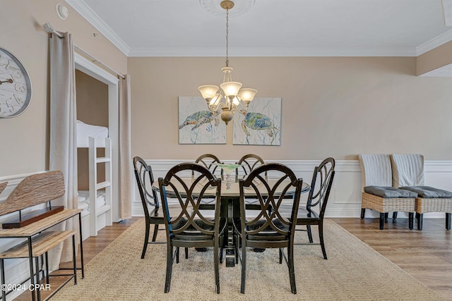 dining room featuring ornamental molding, wood finished floors, and a chandelier