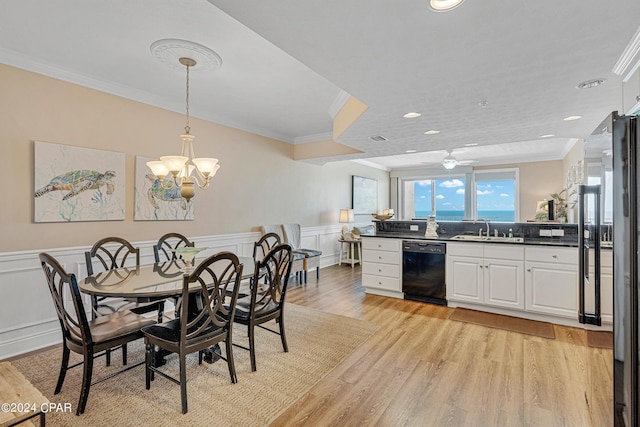 dining space with a wainscoted wall, ornamental molding, recessed lighting, ceiling fan with notable chandelier, and light wood-style floors