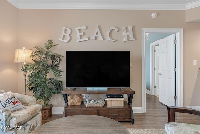 living area with crown molding, baseboards, and wood finished floors