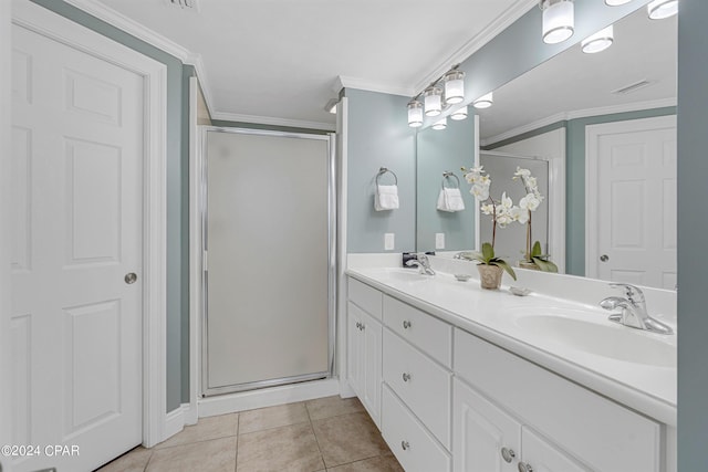 full bath with tile patterned floors, ornamental molding, a shower stall, and a sink