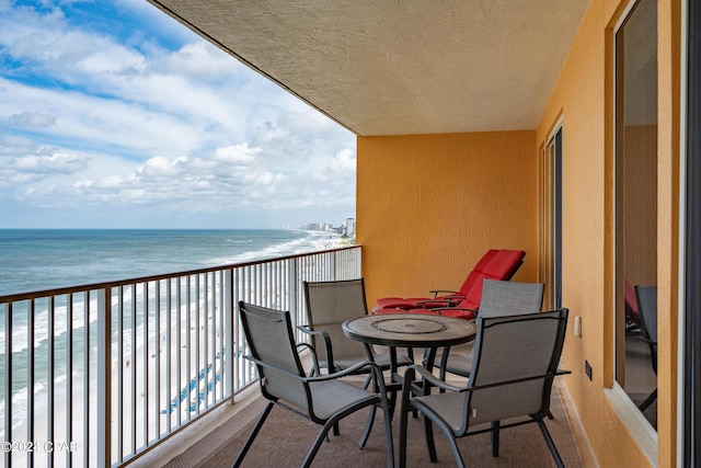 balcony featuring a water view and a beach view