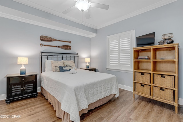 bedroom with a ceiling fan, crown molding, wood finished floors, and baseboards