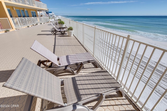 balcony featuring a view of the beach and a water view