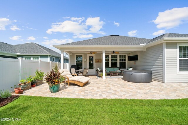 back of property featuring an outdoor hangout area, a patio, ceiling fan, a yard, and a hot tub