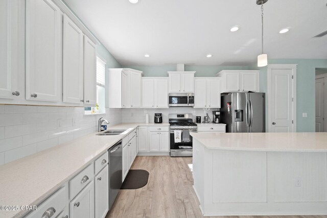 kitchen with decorative backsplash, white cabinetry, pendant lighting, and stainless steel appliances