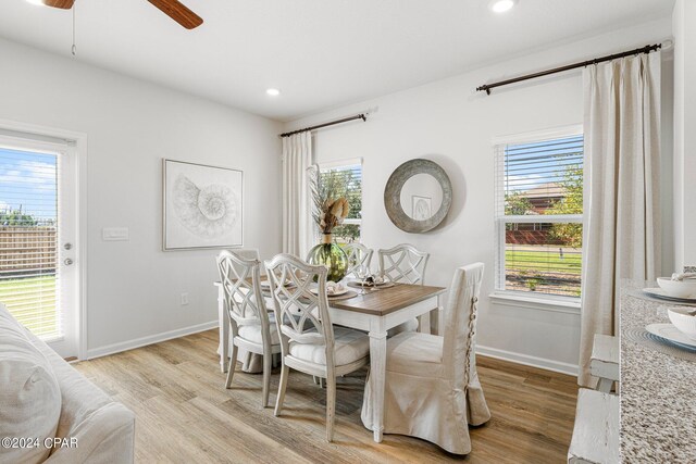 dining space with light hardwood / wood-style flooring and ceiling fan