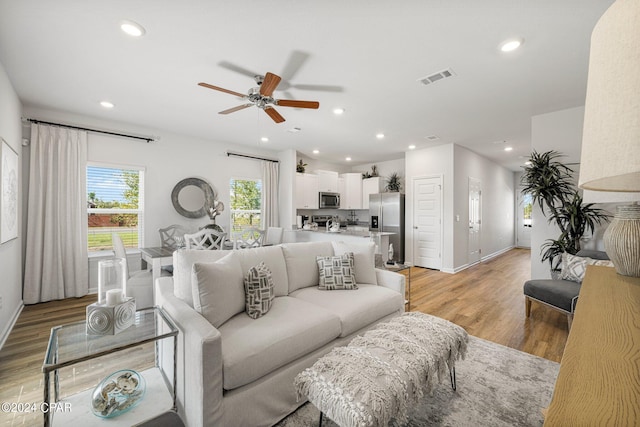 living room with ceiling fan and light wood-type flooring