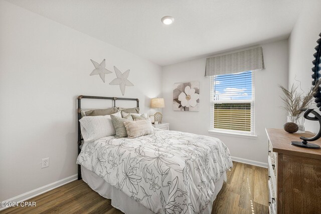 bedroom with dark hardwood / wood-style flooring