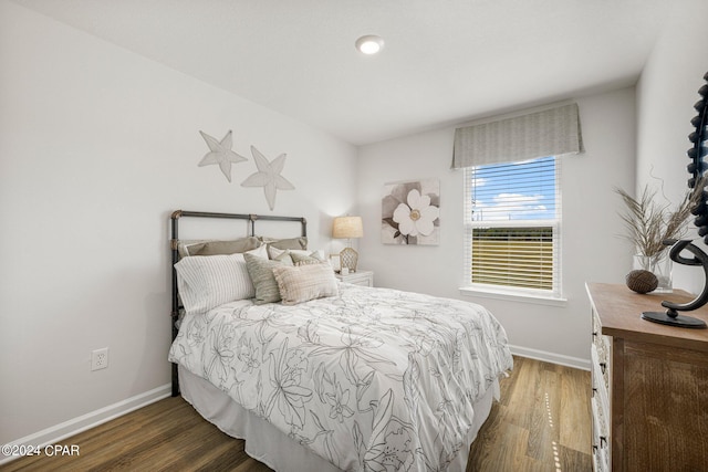 bedroom with dark hardwood / wood-style floors