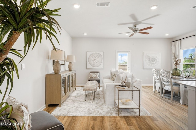 living room with light hardwood / wood-style floors, plenty of natural light, and ceiling fan