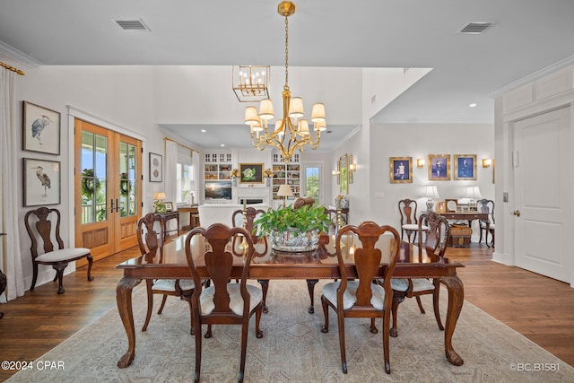 dining space featuring crown molding, dark hardwood / wood-style floors, a chandelier, and french doors