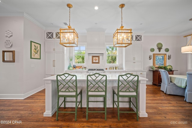 kitchen with hanging light fixtures, a breakfast bar area, and white cabinets