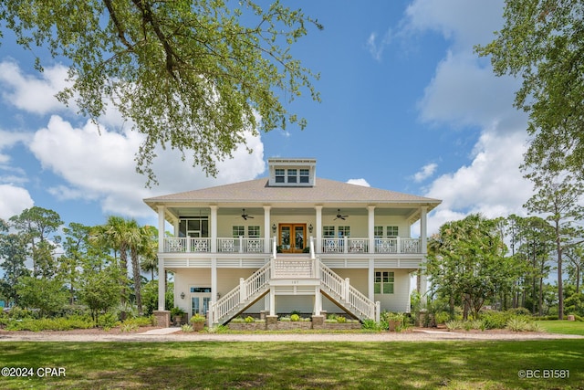 view of front facade with a front yard, ceiling fan, and covered porch