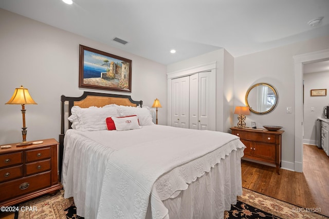 bedroom with light hardwood / wood-style floors and a closet