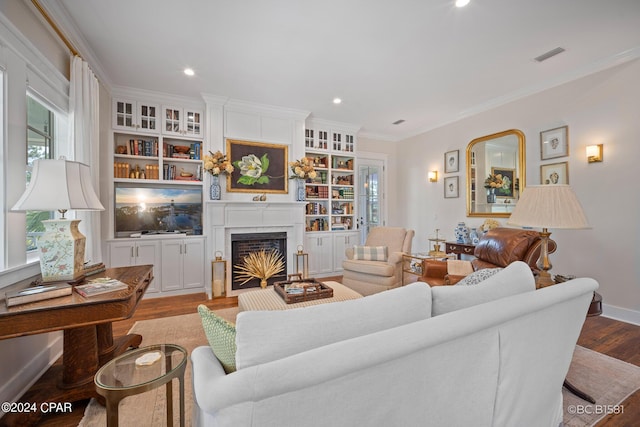 living room with ornamental molding, light hardwood / wood-style floors, and a wealth of natural light