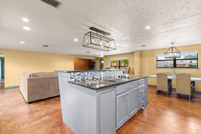 kitchen with a center island, pendant lighting, gray cabinetry, and a wealth of natural light