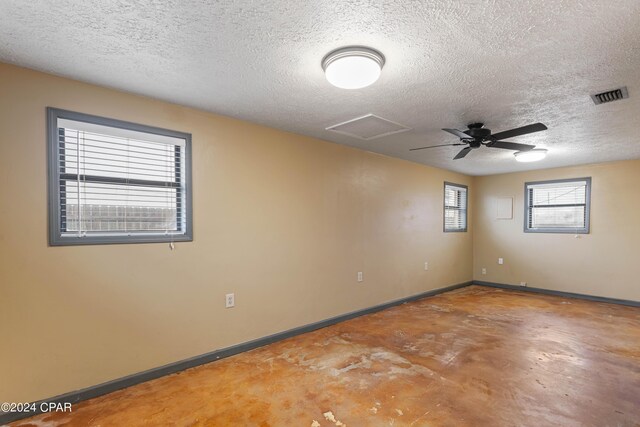 unfurnished room featuring a textured ceiling, ceiling fan, and concrete floors