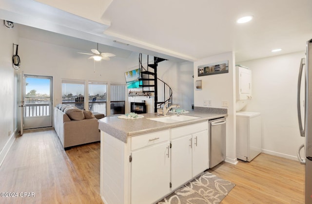 kitchen with dishwasher, white cabinets, sink, light hardwood / wood-style floors, and kitchen peninsula