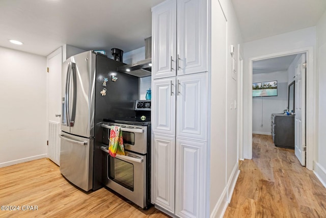 kitchen with stainless steel appliances, light hardwood / wood-style flooring, white cabinetry, and wall chimney exhaust hood