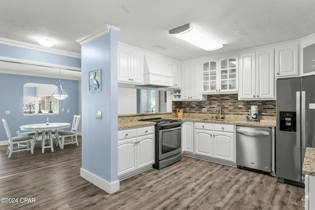 kitchen featuring hardwood / wood-style flooring, premium range hood, light stone countertops, and appliances with stainless steel finishes