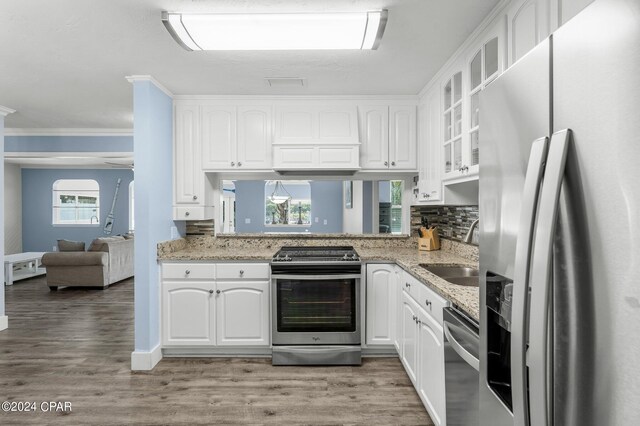 kitchen featuring sink, wood-type flooring, stainless steel appliances, and ornamental molding