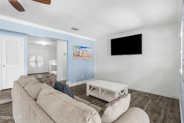 living room with dark hardwood / wood-style flooring, ceiling fan, and crown molding