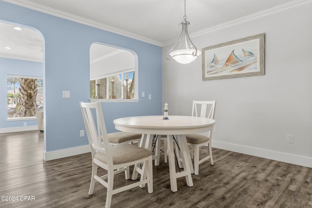 dining room featuring plenty of natural light, arched walkways, crown molding, and wood finished floors